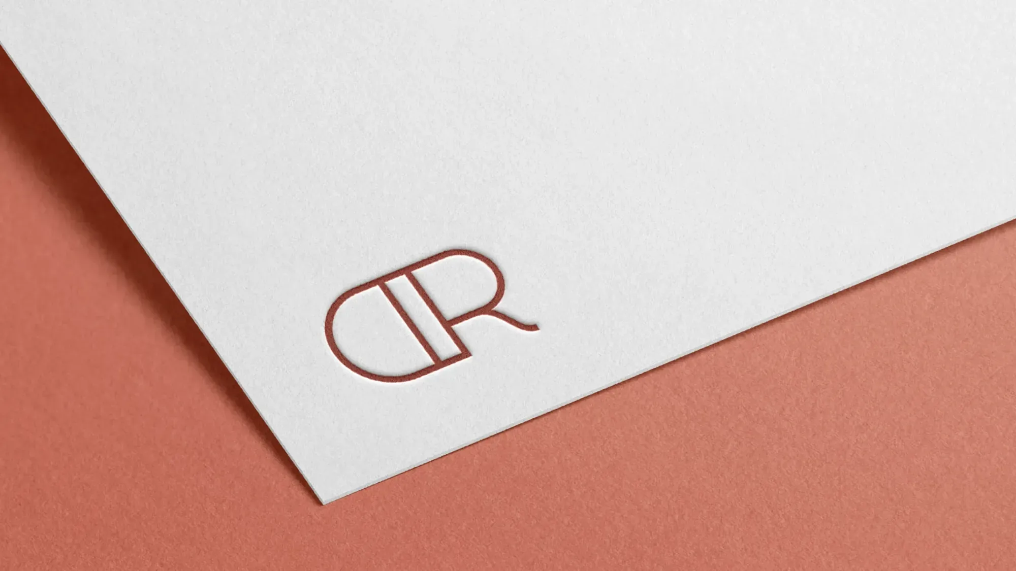 Deer Ridge DR monogram letterpressed in rust on white card over a terracotta background