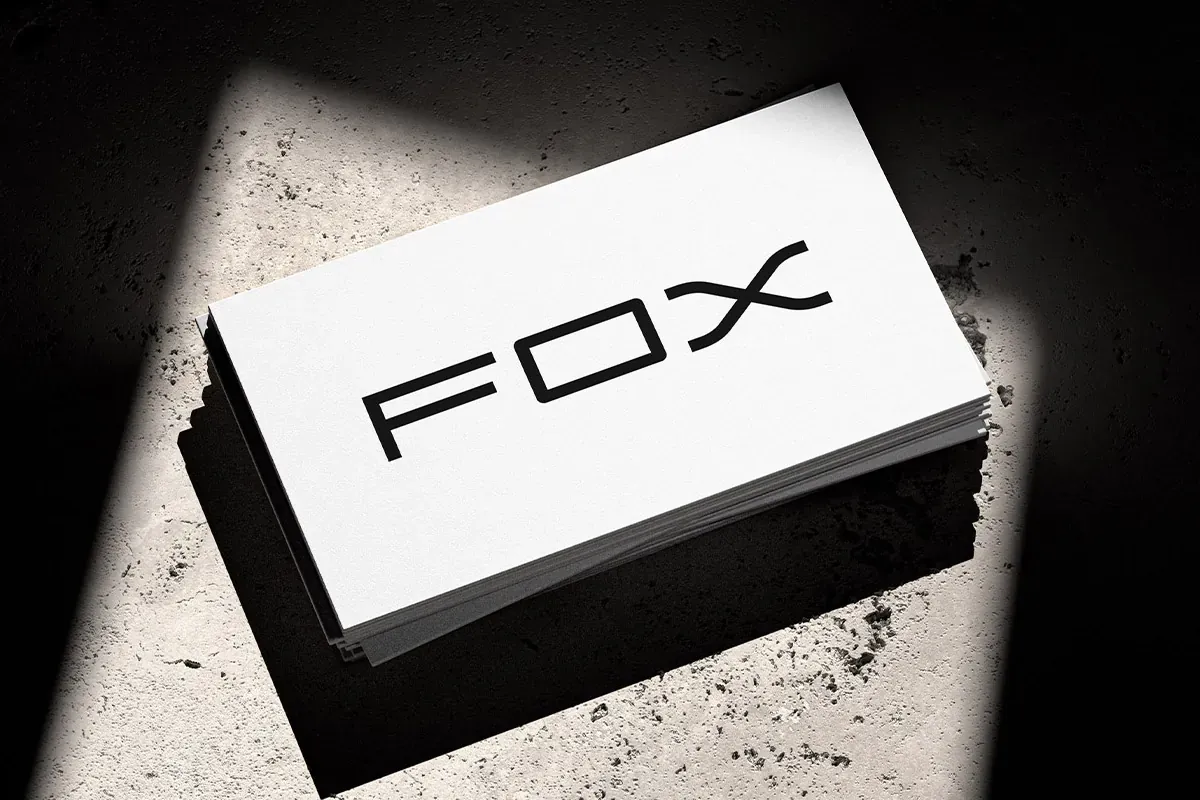 Stack of white Fox Contracting business cards with a bold black logo under a spotlight