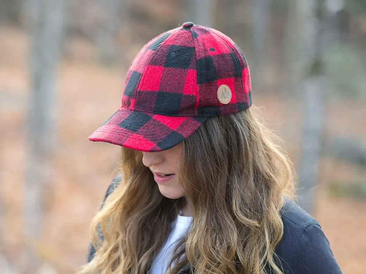 Woman wearing a red and black buffalo plaid cap outdoors