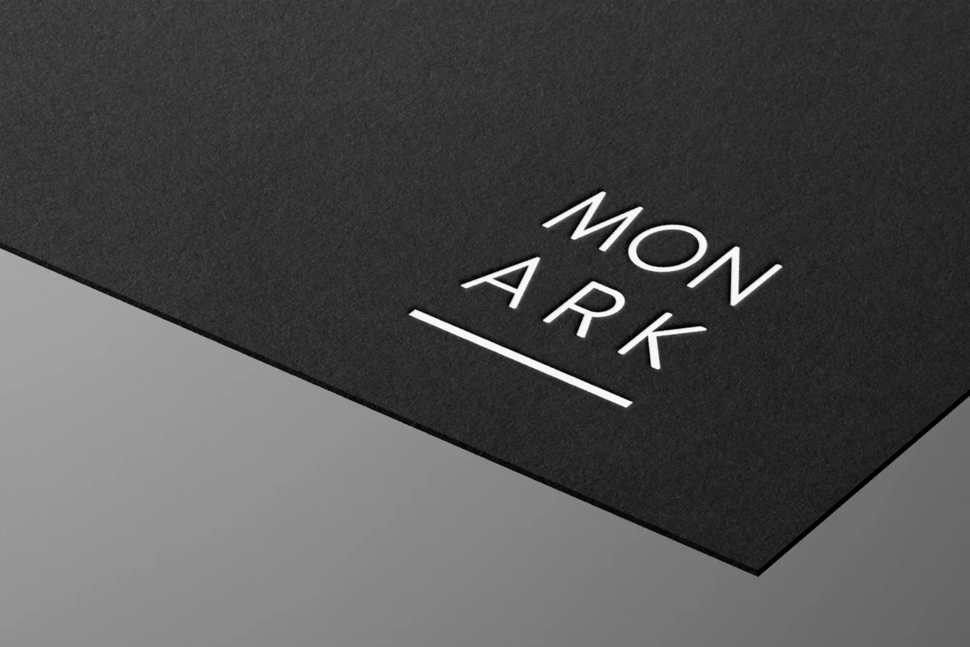 MON ARK logo in white on black textured stationery