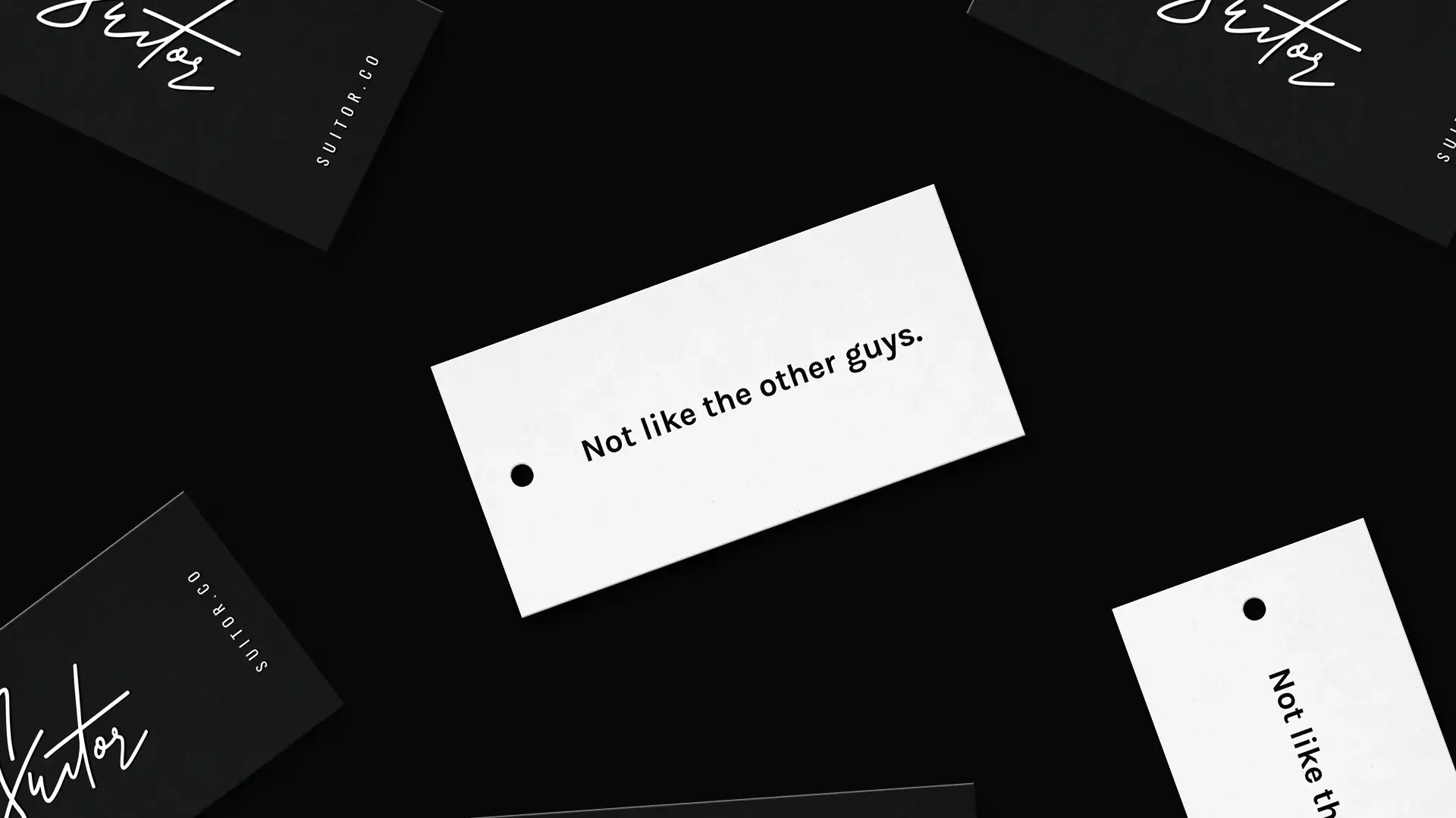 Suitor clothing hang tags in black and white, one reading Not like the other guys