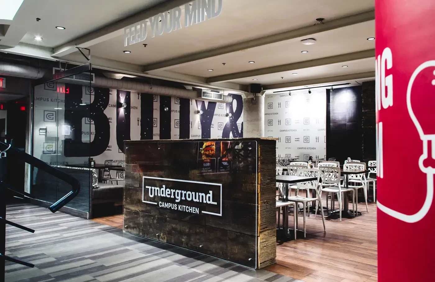 Underground Campus Kitchen dining room with a wood-clad counter and large wall graphics